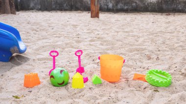 Kamu parkındaki oyun alanındaki kum tarlasına yerleştirilmiş kum kovası oyuncağı.