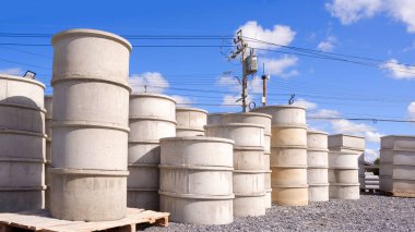 Nalbur dükkanının dışında yere yığılmış farklı çaplara sahip beton kuyu halkaları grubu