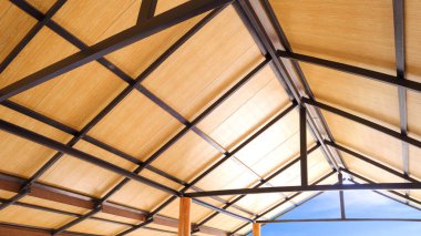 Tavan ahşap PVC plastik kompozit paneller. İnşaat halinde, düşük açılı ve perspektif kenarlı vintage evin metal çatı kiriş yapısı.