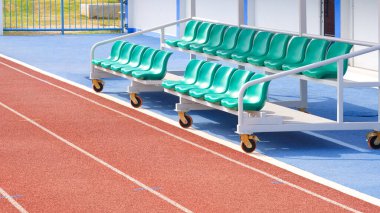 Açık hava futbol stadyumunda kırmızı sentetik koşu pistleri olan kauçuk zeminde yedek ve antrenörlük tezgahı, fotokopi alanı ile perspektif yan görünümü