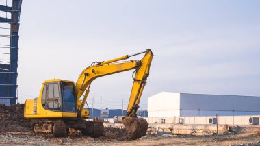 Kazıcı endüstriyel yerleşim alanındaki fabrika şantiyesinin zeminini düzleştiriyor.