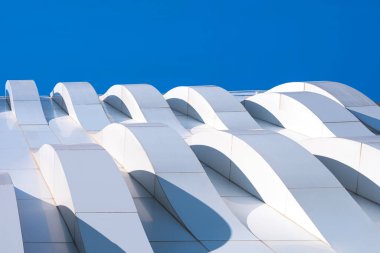 Modern Dış Mimari Dekorasyon Tasarımı, Geometrik Beyaz Alüminyum Bileşik Döşeme Duvarının 3 boyutlu Eğrisi Mavi Gökyüzü Arkaplanına Karşı, Aşağıdan Görünüm