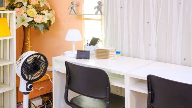 Cep telefonu standı ve masa lambası olan hoparlör modern oturma odasında beyaz ahşap masa üzerinde, ev dekorasyonu tasarımı