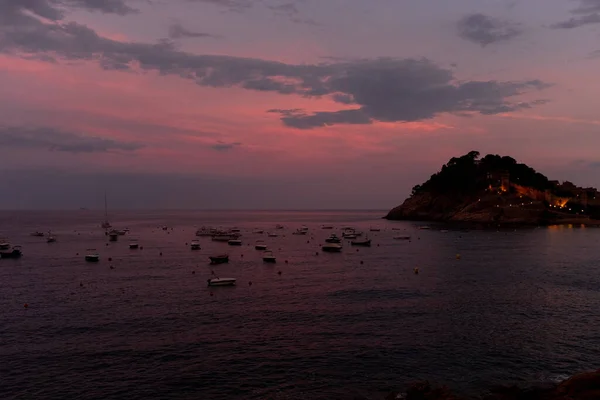 İspanya 'nın Tossa de Mar üzerinde gün batımının güzel renkleri denizin sakin sularını yansıtır.