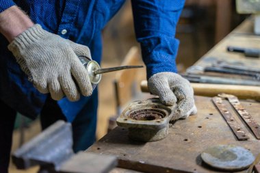 Bir adam atölyede çalışıyor..