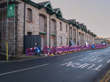 Safety barriers surrounding the old bonded warehouse during its conversion to a Lidl store in Kendal, UK. Lidl is a German discount supermarket expanding in the UK clipart