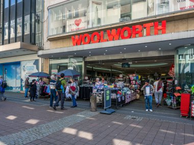 Alışveriş yapanlar yazın yoğun bir alışveriş gününde Kiel 'deki Holstenstrasse' deki Woolworth mağazasına girip çıkıyorlar..