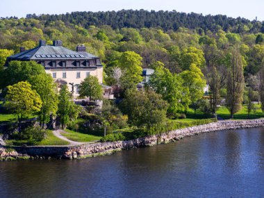 İsveç 'in Stockholm kenti yakınlarındaki rıhtımdaki ağaçlar arasında kurulmuş güzel, zarif ve geleneksel bir İsveç malikanesi. Stockholm takımadaları İsveç 'te 30.000' den fazla adadan oluşan en büyük takımadalardır.