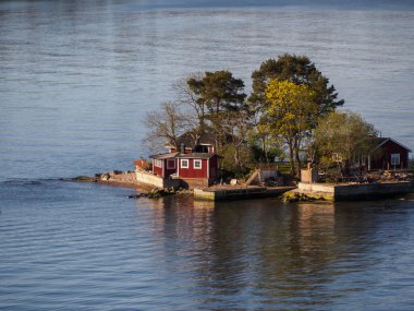 Stockholm Takımadası 'nda, İsveç' in başkenti Stockholm 'e yakın, güzel, kırmızı boyalı, ahşap bir tatil evi olan ağaçlık bir adanın yüksek manzarası. Takımadanın 30.000 'den fazla adası ve 50.000' den fazla tatil evi var..