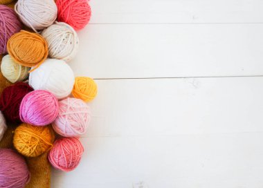 beyaz ahşap zemin üzerinde çok renkli yün toplar yazı için boşluk, pembe, sarı, beyaz, arkaplan