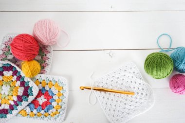 Beyaz ahşap zeminde el yapımı metinler için yeri olan örgü örülü yün toplar.