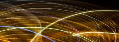 Soyut uzun pozlama. Orijinal ışık resmi. Kıvrımlı çizgiler ya da parlak parlak neon metalik altın dalgaları siyah arka plana karşı. Noel tatili mevsimlik duvar kağıdı dekorasyonu.