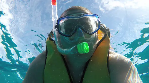 Close-up of a man underwater. A man in a mask and with a snorkel.