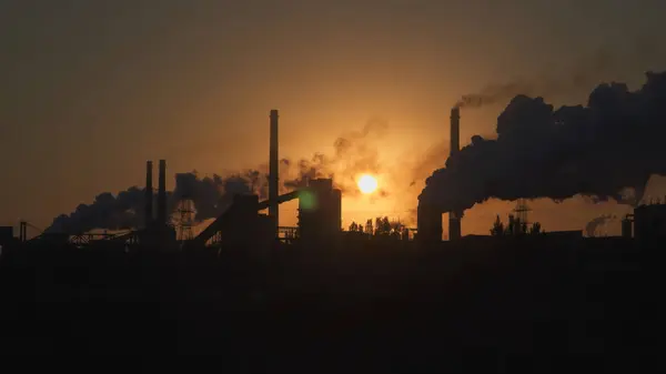 Environmental pollution. Smoke from the pipes on the background of the dawn