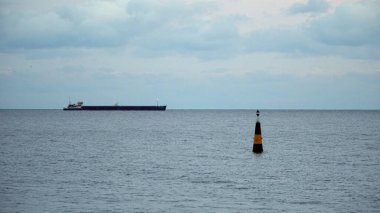 Kargo gemisi ve deniz şamandırası. Akşam vakti.