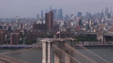 Brooklyn köprüsünün tepesinde Amerikan bayrağı etrafında uçan bir yörünge.