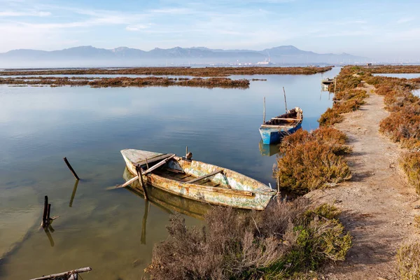 stock image Sardinia, Italy, 2022 December - Old wooden rowing boat moored at the pier on the water.