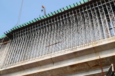 İnşaat alanında sahte işler. Yapısı kendini destekleyecek kadar gelişene kadar kalıcı bir yapıyı desteklemek için kullanılan geçici yapılardan oluşur..