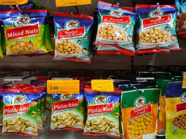 SELANGOR, MALAYSIA -4 HAZİRAN 2022: Fıstık bazlı atıştırmalıklar ticari paketlerde paketlendi ve satışa sunuldu. Markaya göre sıralanmış ve fiyat etiketi var.. 