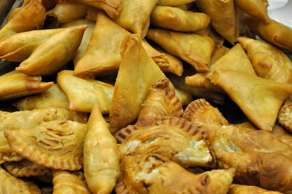 Selected focus of curry puff and samosa randomly put in the containers.