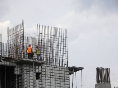 KUALA LUMPUR, MALAYSIA - 26 AĞUSTOS 2017: İnşaat işçilerinin inşaat alanında dikey çelik takviye çubuğu üretmesi. 