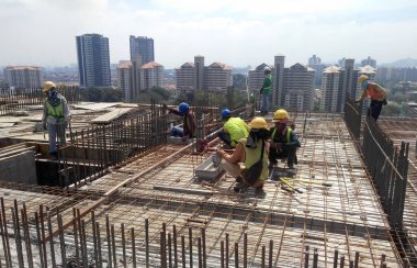 KUALA LUMPUR, MALAYSIA - 26 AĞUSTOS 2017: İnşaat işçilerinin inşaat alanında dikey çelik takviye çubuğu üretmesi. 