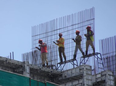 KUALA LUMPUR, MALAYSIA - 26 AĞUSTOS 2017: İnşaat işçilerinin inşaat alanında dikey çelik takviye çubuğu üretmesi. 