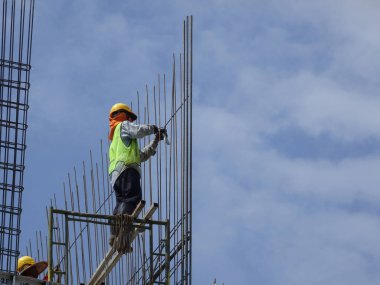 KUALA LUMPUR, MALAYSIA - 26 AĞUSTOS 2017: İnşaat işçilerinin inşaat alanında dikey çelik takviye çubuğu üretmesi. 