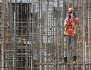 KUALA LUMPUR, MALAYSIA - 26 AĞUSTOS 2017: İnşaat işçilerinin inşaat alanında dikey çelik takviye çubuğu üretmesi. 