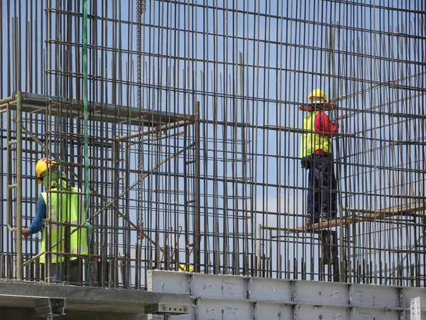 stock image KUALA LUMPUR, MALAYSIA -AUGUST 26, 2017: Construction workers fabricating vertical steel reinforcement bar at the construction site. 