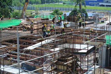 JOHOR, MALAYSIA -15 Mayıs 2016: Gündüz vakti Malezya 'nın Johor şehrinde inşaat çalışmaları sürüyor. İşçiler görev yükleme ve takviye çubuğu ile meşguller. 