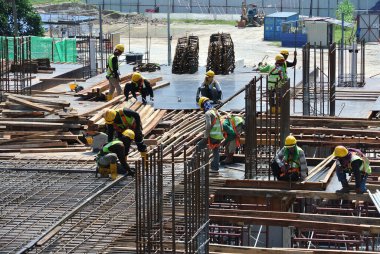 JOHOR, MALAYSIA -15 Mayıs 2016: Gündüz vakti Malezya 'nın Johor şehrinde inşaat çalışmaları sürüyor. İşçiler görev yükleme ve takviye çubuğu ile meşguller. 