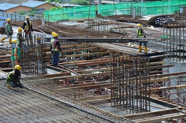 JOHOR, MALAYSIA -15 Mayıs 2016: Gündüz vakti Malezya 'nın Johor şehrinde inşaat çalışmaları sürüyor. İşçiler görev yükleme ve takviye çubuğu ile meşguller. 