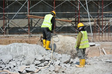 JOHOR, MALAYSIA -JANUARY 13, 2015: A construction workers cutting foundation pile using hacking method at the construction site. He using the heavy duty mobile hacker machine.  