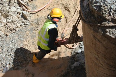 JOHOR, MALAYSIA -JANUARY 13, 2015: A construction workers cutting foundation pile using hacking method at the construction site. He using the heavy duty mobile hacker machine.  