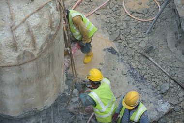 JOHOR, MALAYSIA -JANUARY 13, 2015: A construction workers cutting foundation pile using hacking method at the construction site. He using the heavy duty mobile hacker machine.  