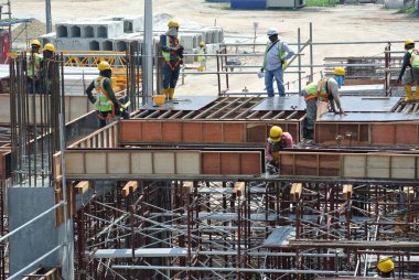 JOHOR, MALAYSIA -15 Mayıs 2016: Gündüz vakti Malezya 'nın Johor şehrinde inşaat çalışmaları sürüyor. İşçiler görevleriyle meşguller. Form işleri, takviye çubuğu ve diğer görevlerle..   