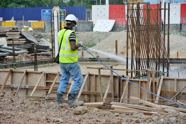 stock image JOHOR, MALAYSIA -JUNE 26, 2015: Construction workers spraying the anti termite chemical treatment to the soil at the construction site. 