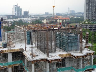 JOHOR, MALAYSIA - 18 Haziran 2020: İnşaat çalışmaları bir şantiyede devam ediyor. Sitenin güvenliği çok ciddiye alınır ve vurgulanır. İnşaat işçileri meşgul..