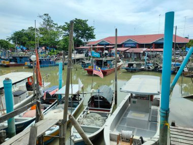 MELAKA, MALAYSIA - 6 Ocak 2022: Malezya 'da küçük bir balıkçı köyündeki tipik atmosfer. Rıhtımda küçük tekneler park edilmiş, para kazanmak için doğru zamanı bekliyorlar..