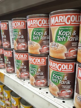 MELAKA, MALAYSIA -5 Nisan 2022: Şekerli krema ve buharlaştırılmış süt kutularda paketlendi. Süpermarketin içindeki rafta satılık. Ana bileşen palmiye yağı tohumlarından yapılır..