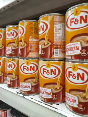 MELAKA, MALAYSIA -5 Nisan 2022: Şekerli krema ve buharlaştırılmış süt kutularda paketlendi. Süpermarketin içindeki rafta satılık. Ana bileşen palmiye yağı tohumlarından yapılır..