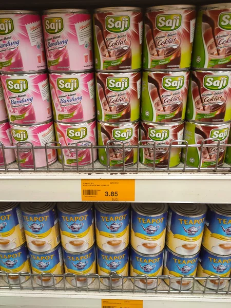 Stock image MELAKA, MALAYSIA -APRIL 5, 2022: Sweetened creamer and evaporated milk packed in cans. Displayed for sale on the rack inside the supermarket. The main ingredient is made from palm oil seeds.