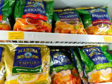 SELANGOR, MALAYSIA - 15 Nisan 2021: Dev süpermarketteki soğutucu buzdolabının içine yerleştirilmiş çeşitli markalarda tavuk nugget ticari ambalajına odaklanmış.