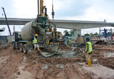 Johor, Malezya-01 Nisan 2015: geçişli kazık betonlama çalışmaları inşaat sahasında. Islak beton dökmek veya geçişli yığın kasa içine beton kamyon Pompası.