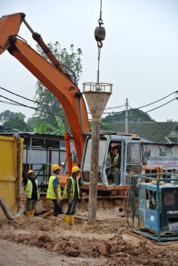 Johor, Malezya-01 Nisan 2015: geçişli kazık betonlama çalışmaları inşaat sahasında. Islak beton dökmek veya geçişli yığın kasa içine beton kamyon Pompası.