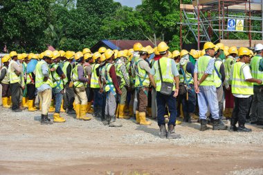 PERAK, MALAYSIA -AYRIL 27, 2016: İnşaat işçileri inşaat alanındaki açık alanda toplanıyor. 