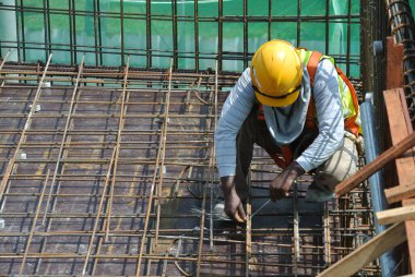 MALACCA, MALAYSIA - 4 Mayıs 2016: Malezya 'nın Malacca kentindeki inşaat alanında döşeme takviye barı üreten inşaat işçileri.  