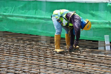 MALACCA, MALAYSIA - 4 Mayıs 2016: Malezya 'nın Malacca kentindeki inşaat alanında döşeme takviye barı üreten inşaat işçileri.  