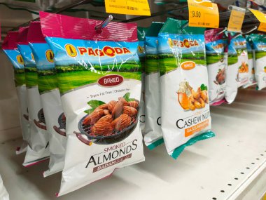 SELANGOR, MALAYSIA - 5 Şubat 2022 Fıstık bazlı atıştırmalıklar ticari paketlerde paketlendi ve satışa sunuldu. Markaya göre sıralanmış ve fiyat etiketi var.. 